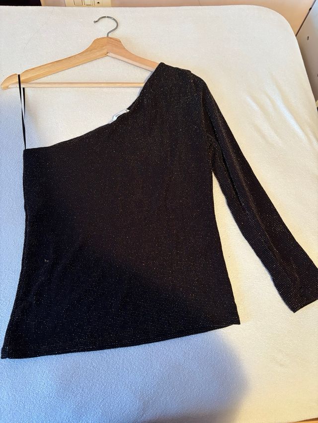 Top asimétrico negro con brillos dorados