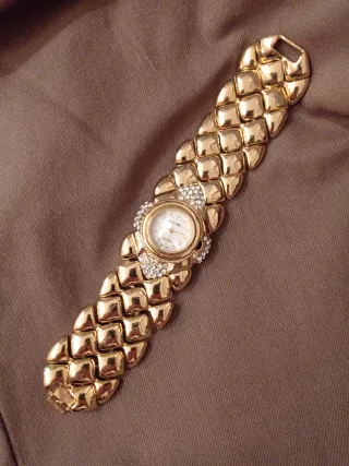 Elegante reloj dorado con pedrería