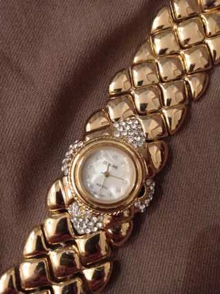 Elegante reloj dorado con pedrería