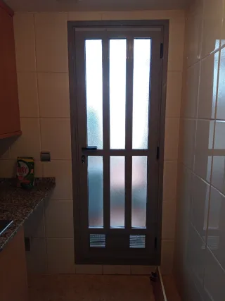 Puerta aluminio con cristal biselado con cerradura