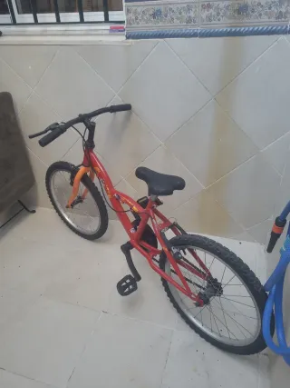 Bicicleta infantil roja y naranja bien cuidada