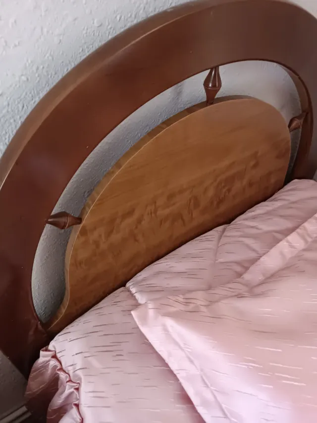 Cama de madera con cabecero curvo