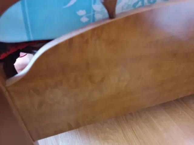 Cama de madera con cabecero curvo