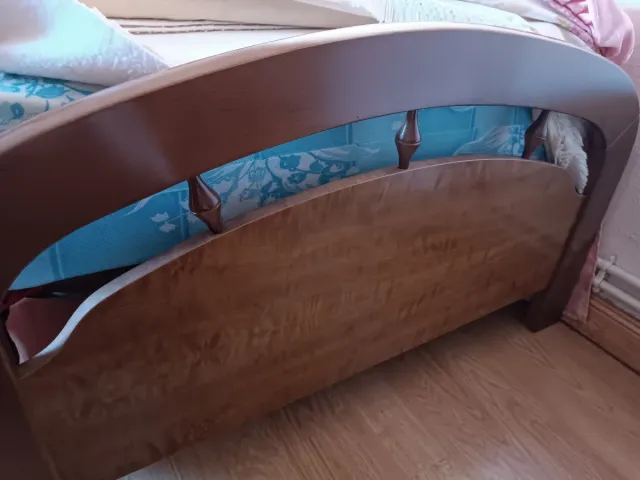 Cama de madera con cabecero curvo
