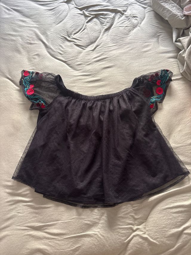 Camiseta negra hombros descubiertos con flores