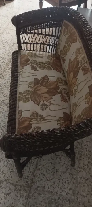 Sofá de mimbre con tela floral.