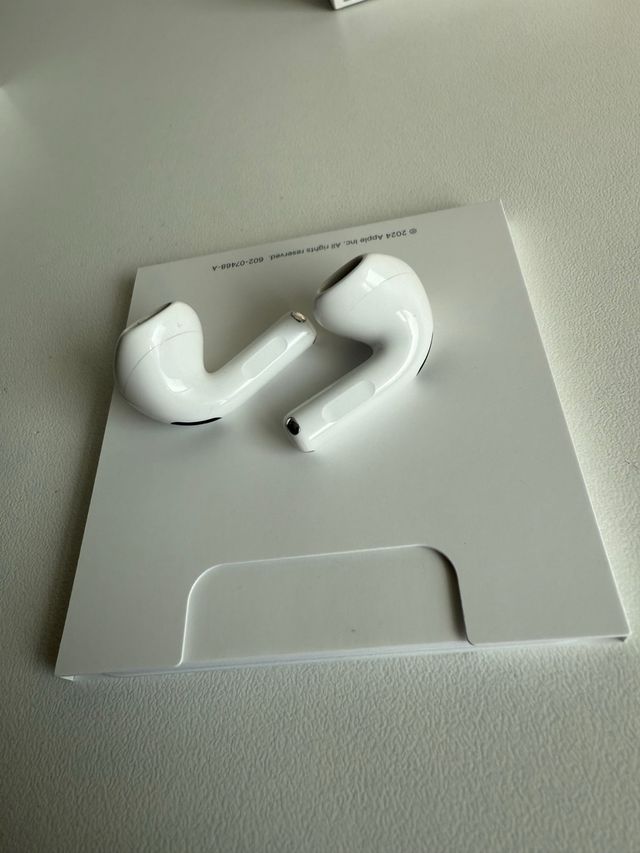 AirPods 4 Blancos con funda azul de regalo.