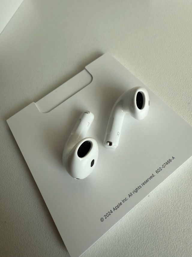AirPods 4 Blancos con funda azul de regalo.