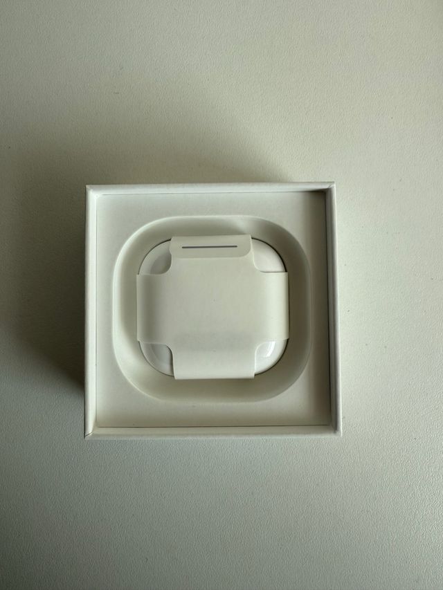 AirPods 4 Blancos con funda azul de regalo.