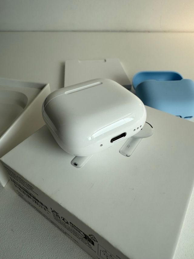 AirPods 4 Blancos con funda azul de regalo.