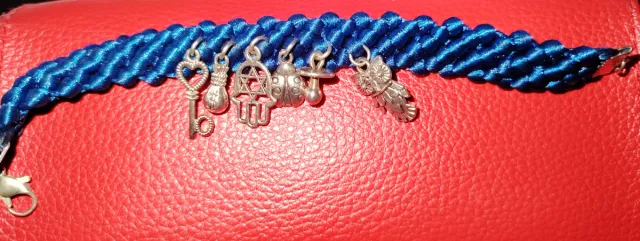 Pulsera trenzada azul con amuletos plateados