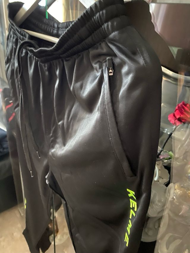 Pantalón deportivo Kelme negro con detalles verde