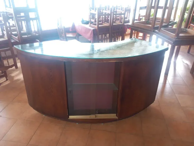 Mostrador curvo de madera y cristal.