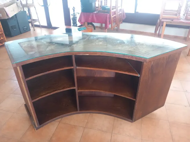 Mostrador curvo de madera y cristal.