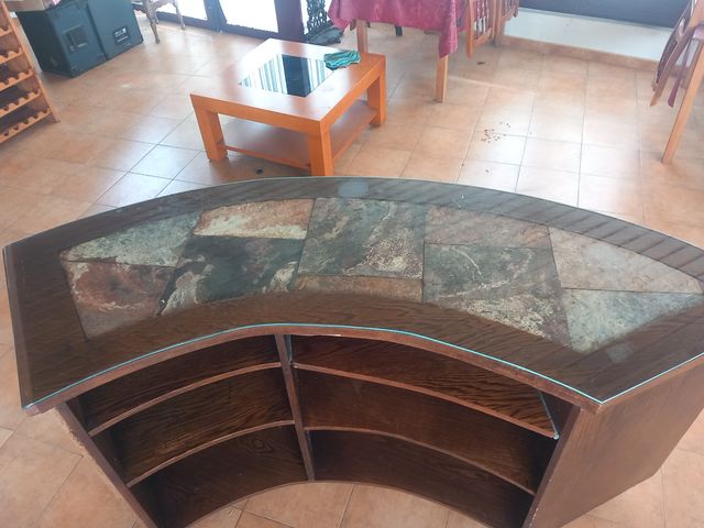 Mostrador curvo de madera y cristal.