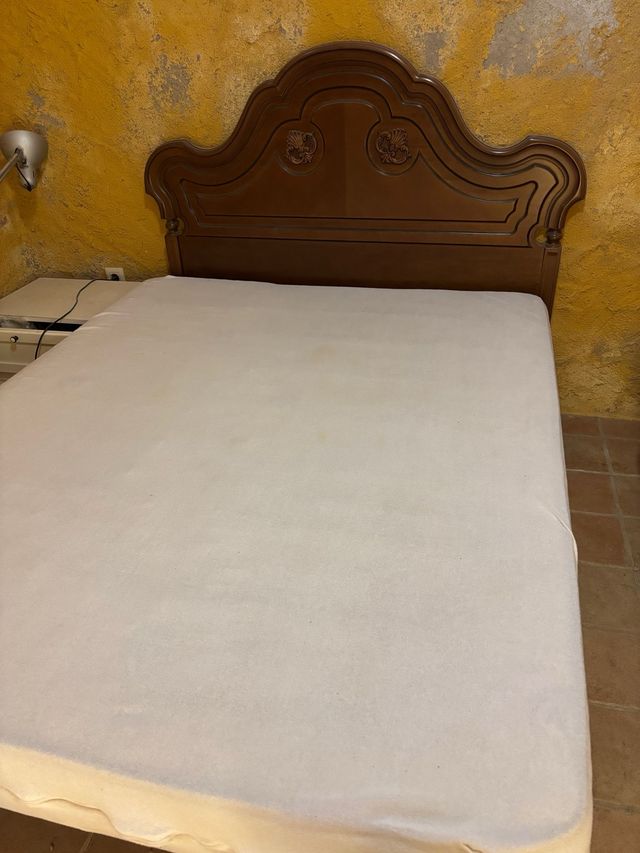 Cama de madera con cabecero tallado