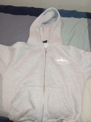 Sudadera Corteiz gris con cremallera y capucha