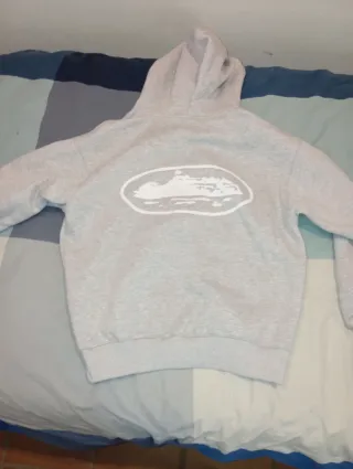 Sudadera Corteiz gris con cremallera y capucha