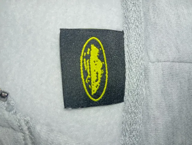 Sudadera Corteiz gris con cremallera y capucha