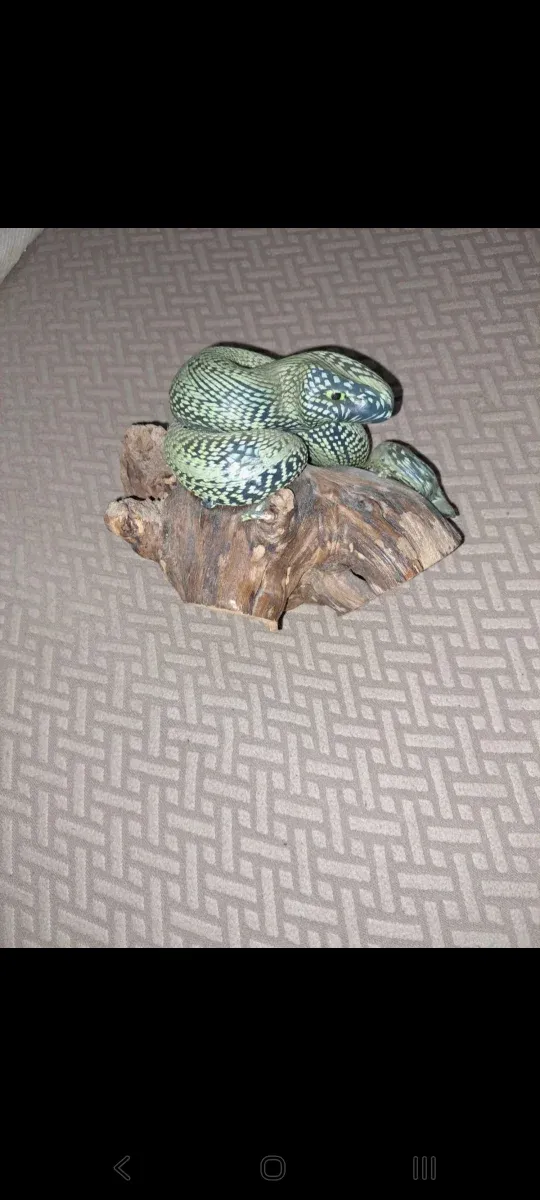 Vela decorativa serpiente sobre tronco de madera