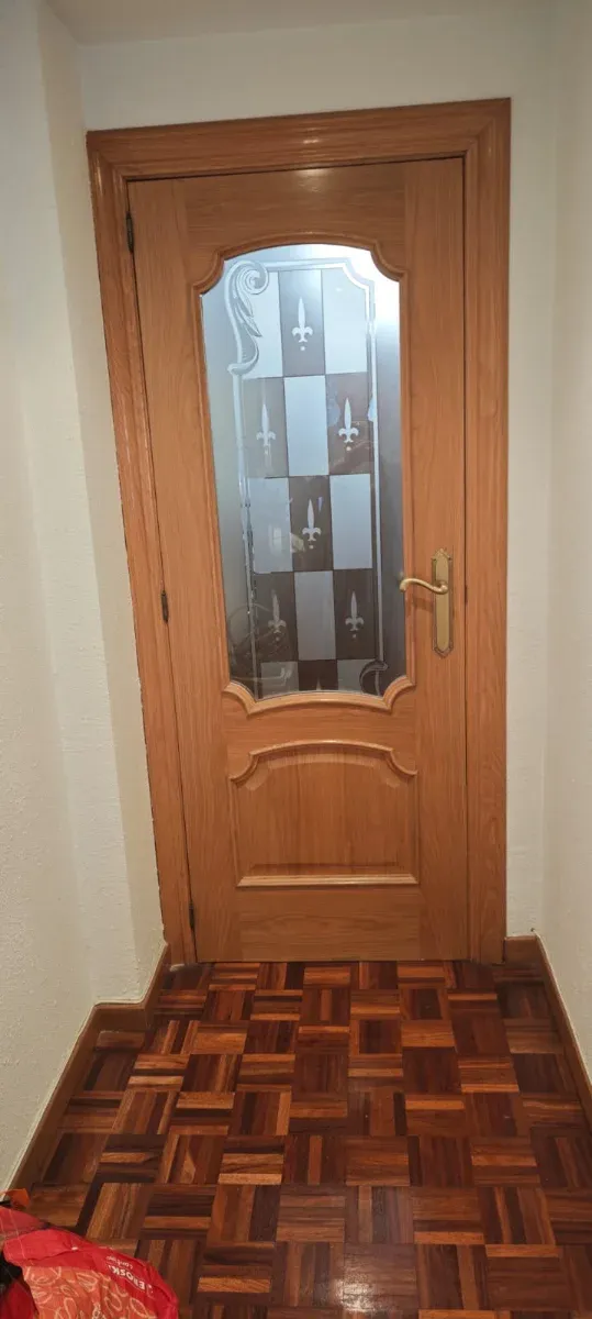 Puerta de interior de madera con cristal.