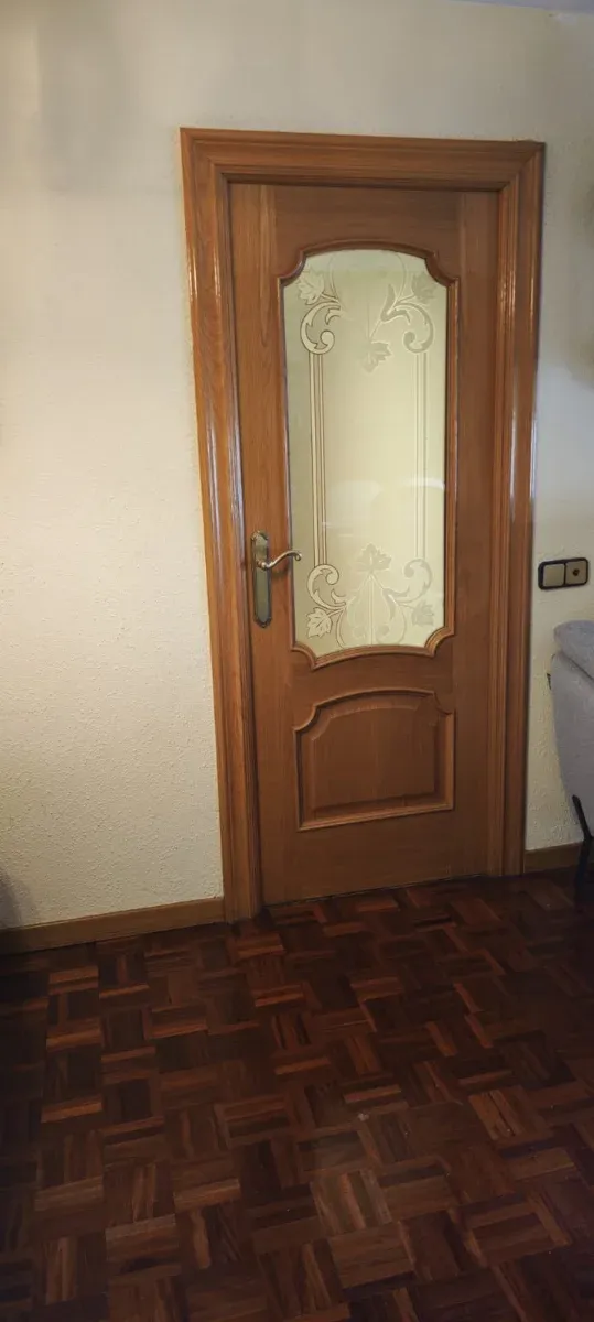 Puerta de interior de madera con cristal.