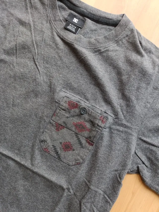 Camiseta DC gris con bolsillo