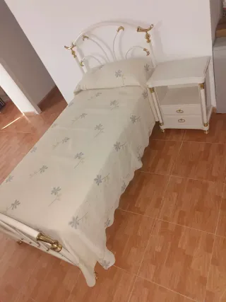Cama blanca y dorada con colchón y mesita de noche