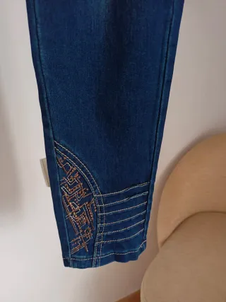 Pantalón vaquero azul con adornos dorados