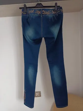 Pantalón vaquero azul con adornos dorados