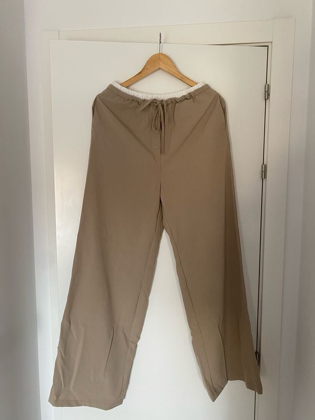 Pantalón beige con cordón y botones.