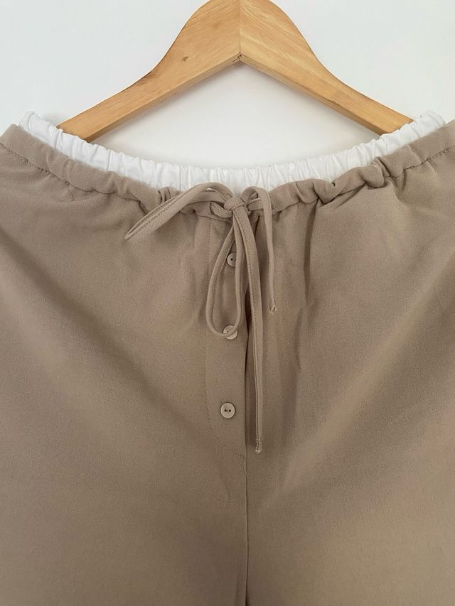 Pantalón beige con cordón y botones.