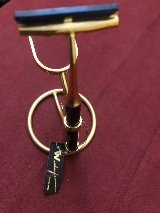 Maquinilla de afeitar dorada con soporte