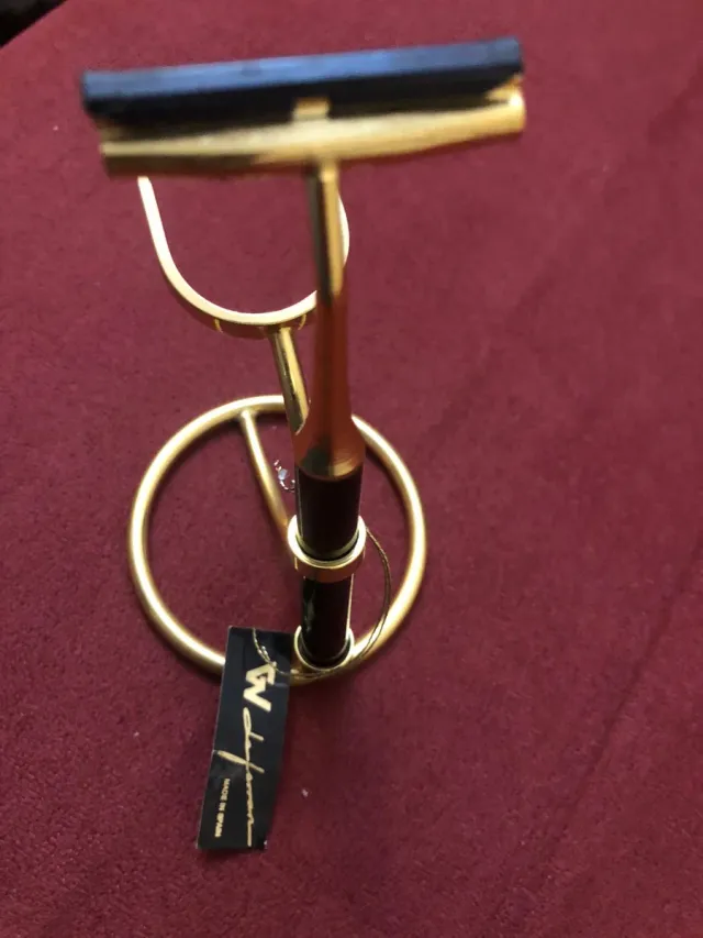 Maquinilla de afeitar dorada con soporte