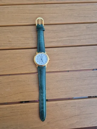 Reloj de pulsera dorado con correa verde