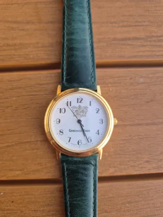 Reloj de pulsera dorado con correa verde