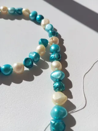 Hilo de perlas naturales beige y azul.
