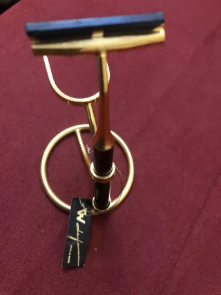 Maquinilla de afeitar dorada con soporte