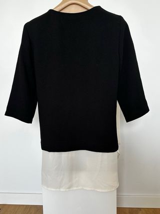 Blusa negra con cremalleras en hombros