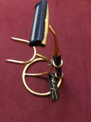 Maquinilla de afeitar dorada con soporte