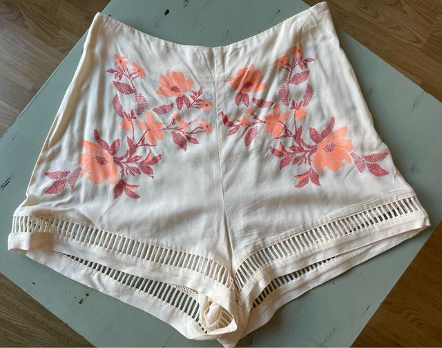 Shorts beige con bordado floral naranja coral