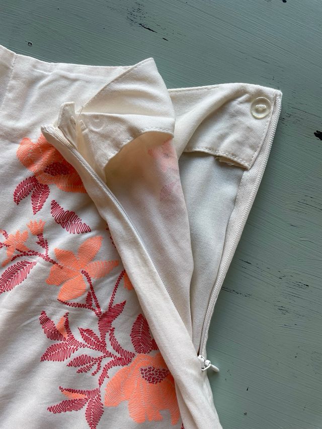 Shorts beige con bordado floral naranja coral