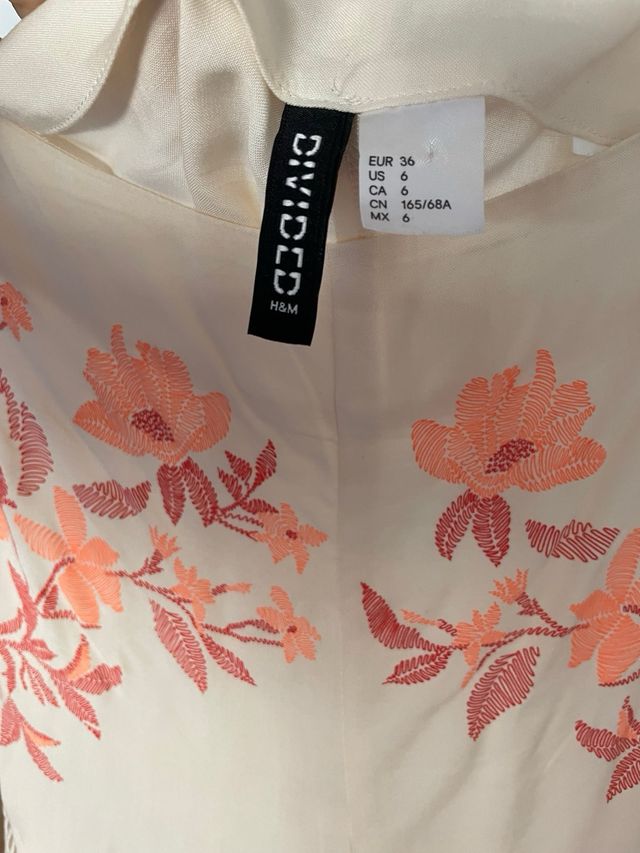 Shorts beige con bordado floral naranja coral