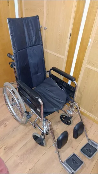 Silla de ruedas alta con cojín.