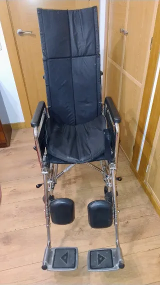 Silla de ruedas alta con cojín.