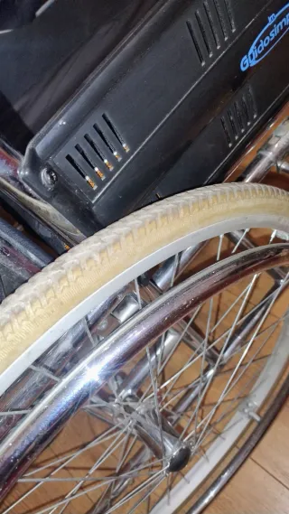 Silla de ruedas alta con cojín.