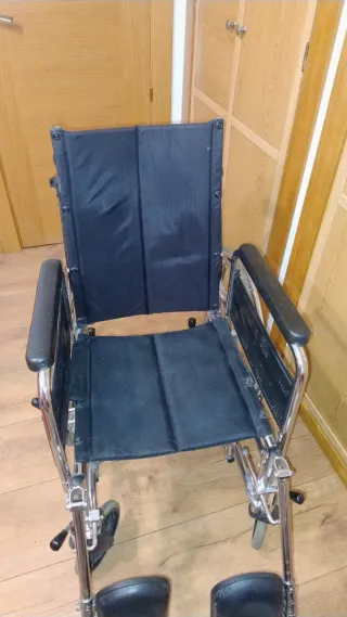 Silla de ruedas alta con cojín.