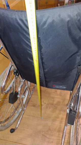 Silla de ruedas alta con cojín.