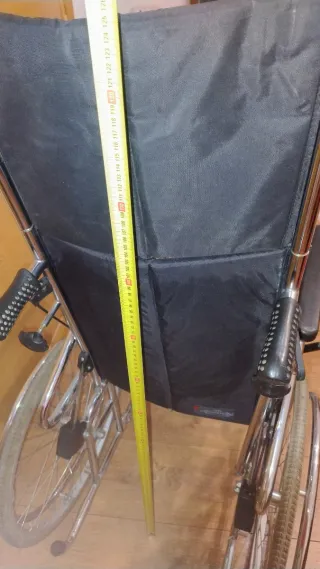 Silla de ruedas alta con cojín.