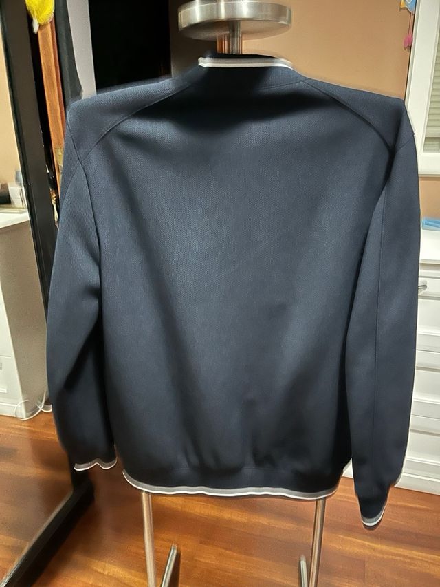 Chaqueta fina Zara negra con detalles blancos.